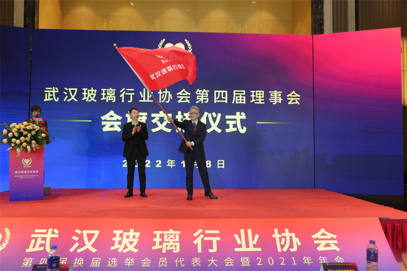 武汉玻璃行业协会第三届会长李松柏把协会会旗移交新任会长刘凌云